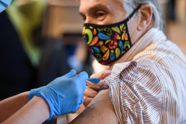A member of the public receives the Oxford/AstraZeneca Covid-19 vaccine (Photo by OLI SCARFF/AFP via Getty Images)