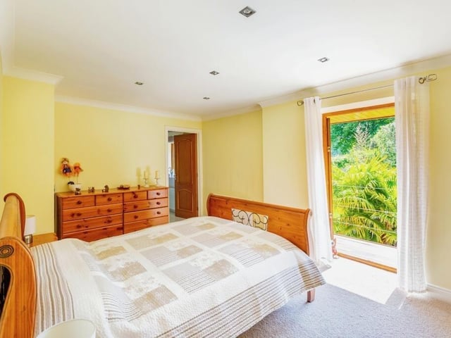 Another first-floor bedroom also includes a balcony with views out onto the garden