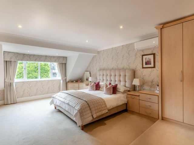 The master bedroom is captured by light thanks to multiple windows and ceiling lights