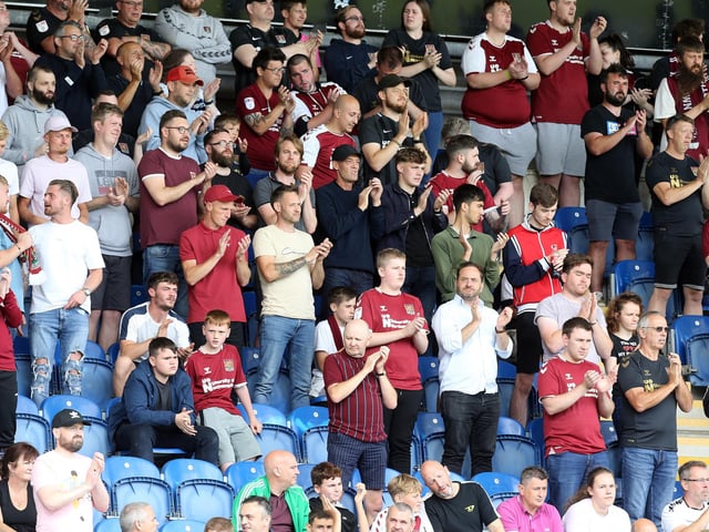 2021: Northampton Town fans take part in a minutes applause to the memory of fans who have passed in the last year prior to the Sky Bet League Two match between Colchester United and Northampton Town at JobServe Community Stadium on August 14, 2021 in Colchester, England. (Photo by Pete Norton/Getty Images)