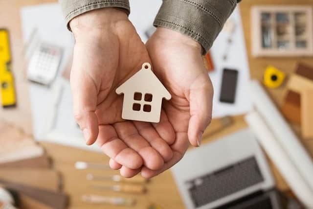 A small house decoration held in cupped hands