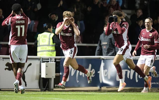 NORTHAMPTON, ENGLAND - DECEMBER 20: Cameron McGeehan of Northampton Town celebrates with Ethan Wheatley and Kamarai Swyer after scoring his second and his sides third goal during the Sky Bet League One match between Northampton Town and AFC Wimbledon at Sixfields on December 20, 2025 in Northampton, England. (Photo by Pete Norton/Getty Images)