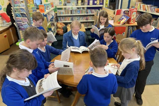 Children reading the book in the library of Spratton CE Primary School