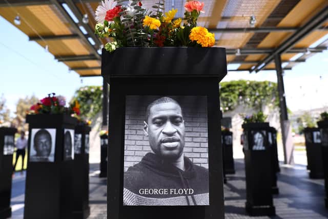 A photograph of George Floyd (C) is displayed along with other photographs at the Say Their Names memorial exhibit at Martin Luther King Jr. Promenade on July 20, 2021 in San Diego, California (Photo by Mario Tama/Getty Images)