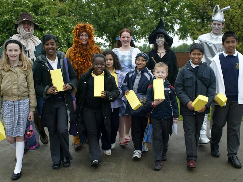 Council staff in Wizard Of Oz costumes, with children from Castle Primary School holding yellow bricks, taking part in walk to school week.