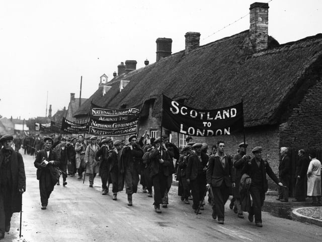 22nd October 1932: The Scottish contingent of the National Hunger March against the National Government marching through the village of Croughton, Northamptonshire. They are some of the 2,000 men and women from all over Britain marching to London to protest against Means Test. (Photo by Topical Press Agency/Getty Images)