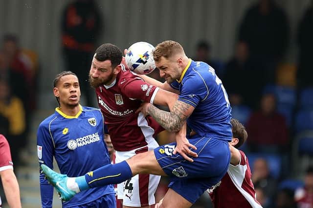 Elliott Moore goes up for a header against Wimbledon