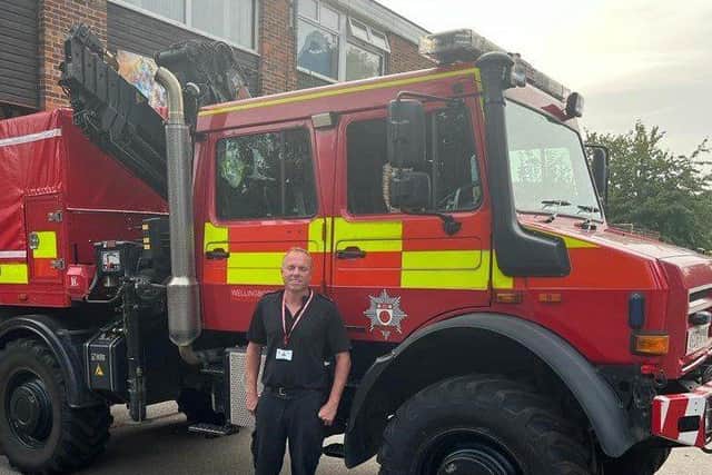 Watch Manager Mick Titcombe in front of Fire Service specialist animal rescue appliance