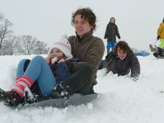 Jamie Holland and Milly Holland, 10, sledge down a hill at the racecourse pushed by William Sey. Thursday, 5th February 2009