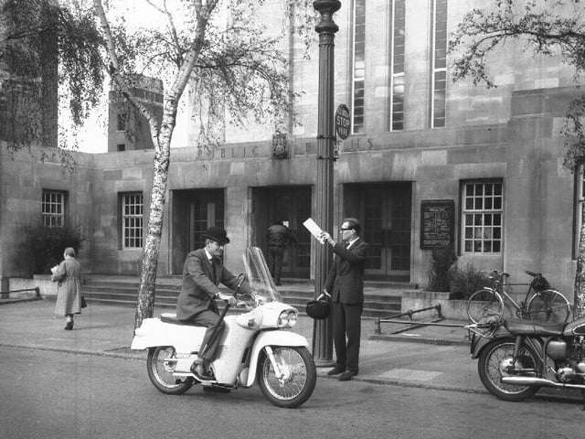 City 'toff' on an enclosed Velocette motorcycle outside the Mounts Baths, Northampton