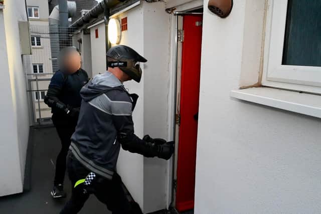 Officers use their big red key to enter one of the homes