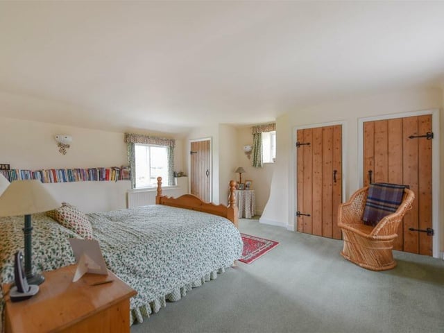One of the property's five bedrooms is oozing with light from windows on all three walls