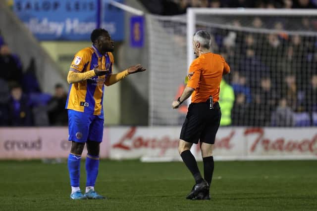 Aaron Pierre is booked by referee Seb Stockbridge. It should have been his second yellow card after the officials cautioned the wrong player in an earlier incident.
