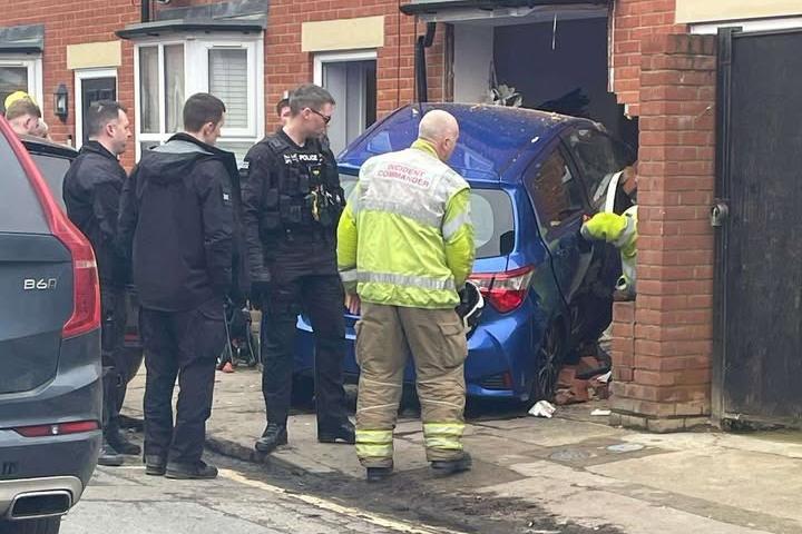 Emergency services called after car crashes into home on busy road in ...