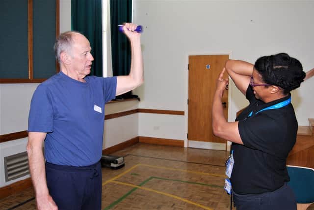 Barry Lilley practices tricep extensions with Exercise Instructor Wendy Romain