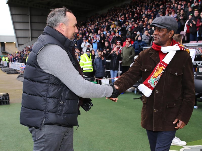 Northampton Town chairman Kelvin Thomas shakes the hand of former player Ian Benjamin after being introduced as part of the 125th anniversary celebrations at half time during the Sky Bet League Two match between Northampton Town and Tranmere Rovers at Sixfields on March 05, 2022 in Northampton, England. (Photo by Pete Norton/Getty Images)