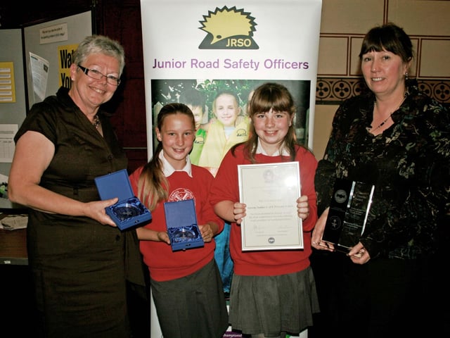 2009: L to R: Teaching assistant Jeanette Waite, Junior Road Safety Officers Lulu Rock and Alanis Smith and head Jan Pickering, from Greens Norton Primary School picking up their trophy for outstanding contribution by a school for road safety in the Impact Awards 2009 ceremony. They won the Liz Tavener Award.