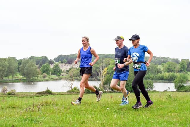 Runners heading out on the half marathon in front of the lake at Deene Park