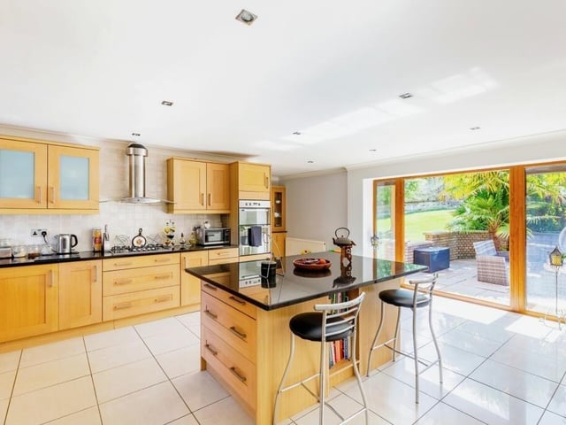 The kitchen is generously proportioned with an island breakfast bar and modern appliances