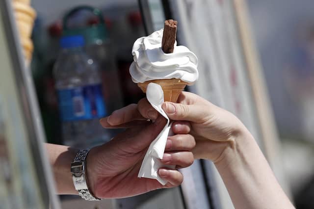 A customer buys an ice cream on a sunny day.