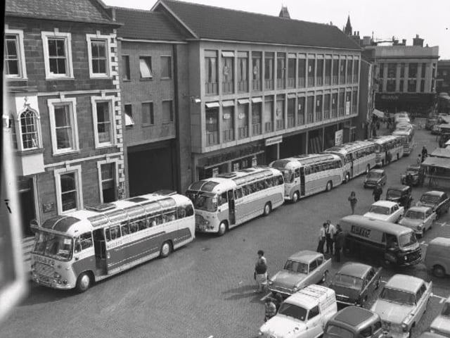 Looking Back old glass negs. At least eight Wesleys coaches gather on Northampton Market Square to take passengers on an outing. Outside the Peacock Place arcade.
September 10, 1964.