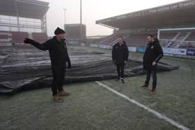 Referee Geoff Eltringham with Cobblers CEO James Whiting and groundsman Paul Knowles during a pitch inspection before Saturday's game against Mansfield.