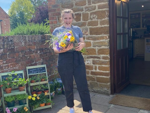 Pippa Reeve is pictured at the entrance of her shop.