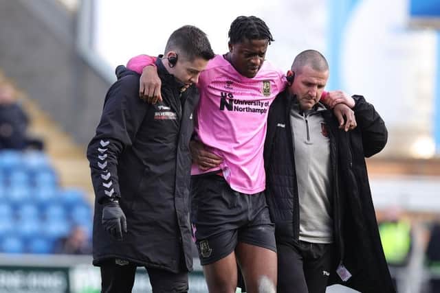 Tyler Magloire is helped from the pitch with a serious knee injury suffered against Colchester United back in February. (Photo by Pete Norton/Getty Images)