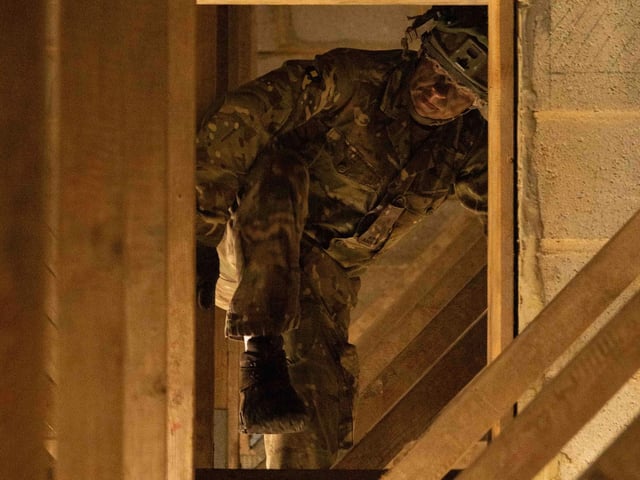 Private Warren from 2nd Battalion The Royal Anglian Regiment crawls through roof rafters during his run through the Confidence Course in Copehill Down. The course was part of the regiment's build up training ahead of their deployment onto Exercise Wessex Storm.