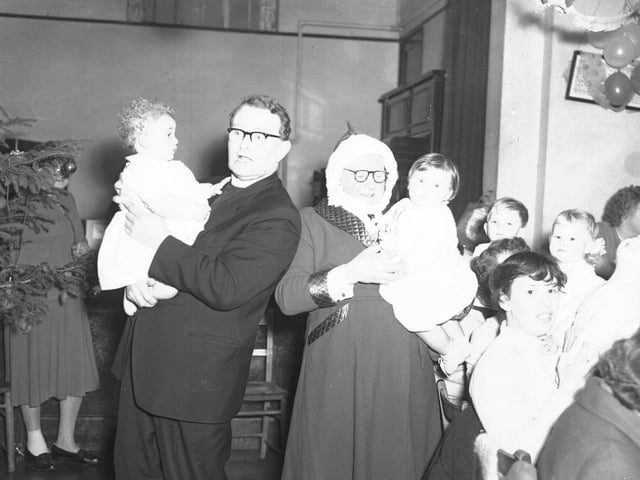 Vicar with babies at Christmas party
