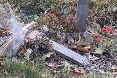A cross on another nearby grave was discovered broken in half.