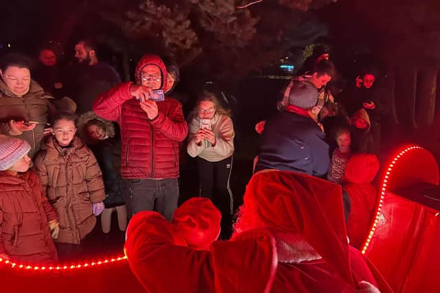 Some of the parents and children speaking to Santa.