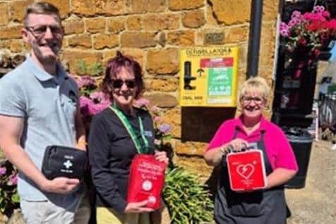 The emergency station at Duston Village Bakery containing an AED with DefibTrack, a bleed control kt and a first aid kit. L to R - Llewyn Mitchell, Duston Parish Council’s Estate Officer, Chair of the Parish Council, Jan Ennis-Clark and Jenni Smith, Duston Village Bakery
