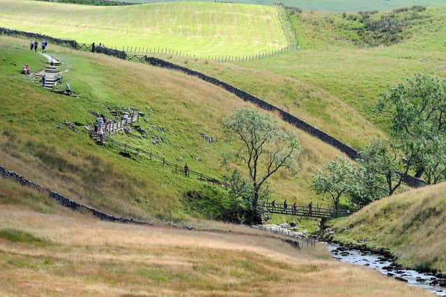 Walkers cross the River Twiss on the Ingleton Waterfalls trail