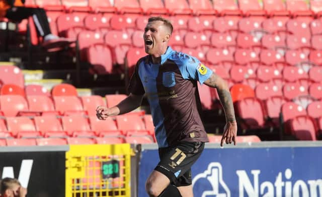 Mitch Pinnock wheels away in delight after netting the winning goal at Swindon Town on Saturday. Pictures: Pete Norton.