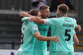 Jon Guthrie and Ben Fox celebrate with Patrick Brough after the defender's goal secured victory for the Cobblers against Exeter City. (Photo by Pete Norton/Getty Images)