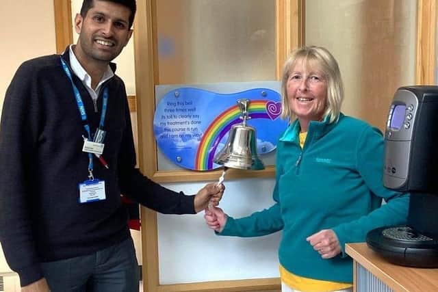 Consultant Therapeutic Radiographer Maulik ‘Maz’ Darji with Sue Broome and the brass bell rung by cancer patients after finishing their treatment