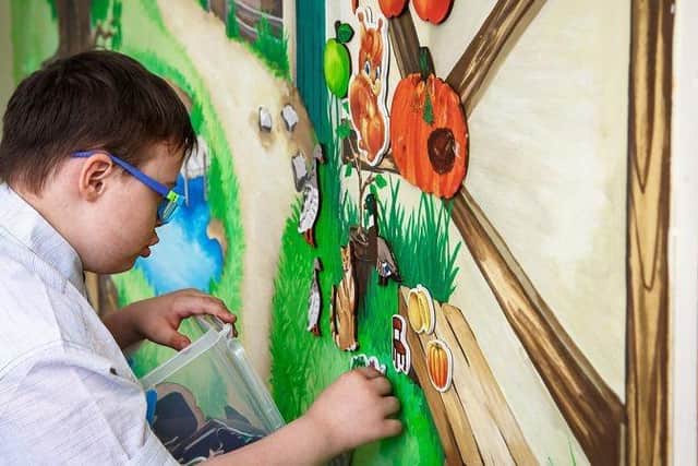 A childing playing with some magnets shaped like animals and objects