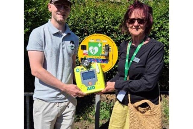 The emergency station at Duston Village Hall containing a defibrillator fitted with DefibTrack. L to R - Llewyn Mitchell, Duston Parish Council’s Estate Officer and Chair of the Parish Council, Jan Ennis-Clark