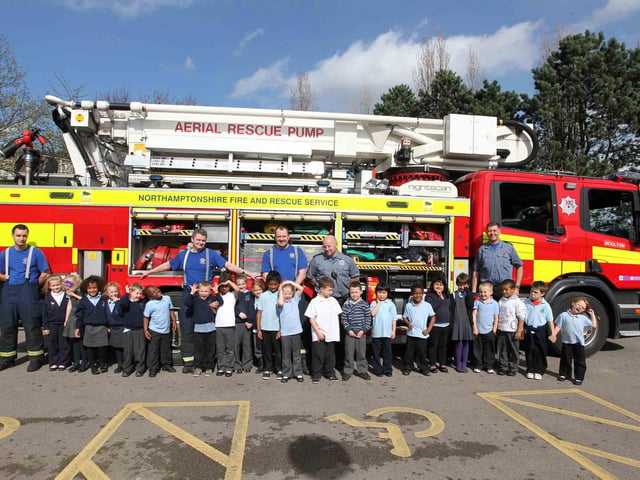 Firefighters from Moulton fire crew visiting children at The Arbours Primary School as part of an emergency services day.  Pictured: Year one children next to the fire engine.