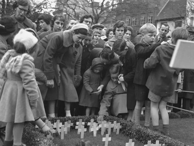 Remembrance service at All Saints Church Northampton, children place poppy crosses
