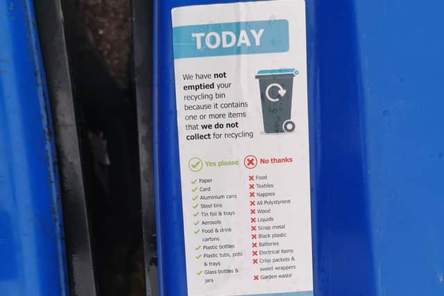 The stickers left on the recycling bins tell residents what can and cannot be put inside