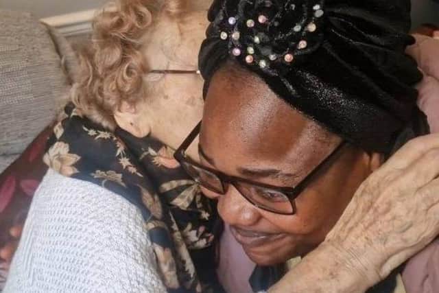 Mamie and one of the Members hug and share some love at the Home