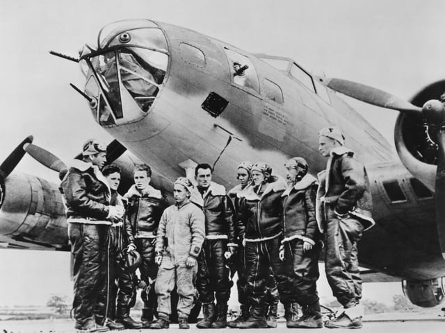 Captain William "Bill Musselwhite (far left) briefs the crew of Peggy Don, a Boeing B-17E Flying Fortress four engined bomber from the 342nd Bombardment Squadron, 97th Bomb Group of the United States Army Air Forces Eighth Air Force before the first Eighth Air Force heavy bomber mission of the war, attacking the Rouen-Sotteville marshalling yards in Nazi German occupied France on 17th August 1942 at RAF Grafton Underwood near Kettering, Northamptonshire, England. (Photo by Three Lions/Hulton Archive/Getty Images).
