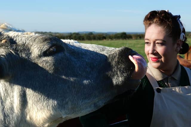 Cast member Olivia feeding the cows