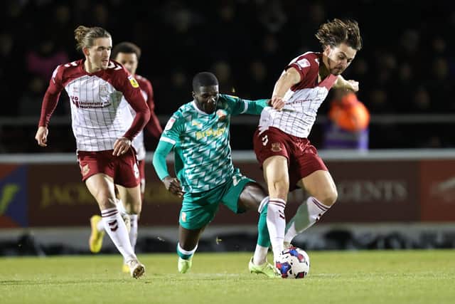 Louis Appere gets the better of Swindon Town's Saidou Khan during Thursday night's Sky Bet League Two clash between the sides at Sixfields (Picture: Pete Norton)