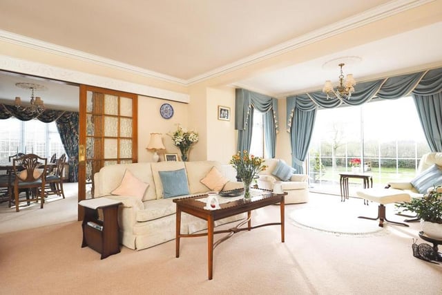 The first reception room to inspect is this bright and beautiful lounge, the largest room in the bungalow. French doors lead to the dining room, and the imposing window overlooks the back garden, river, bridge and all.
