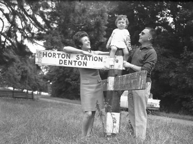 July 28, 1967 - Mr and Mrs Rosemary Remy and child toddler sitting on signpost to Horton Station and Denton
