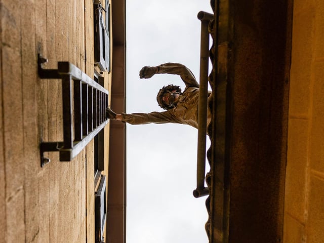 A soldier from 2nd Battalion The Royal Anglian Regiment climbs from one building to the other up a ladder during the final obstacle of the Confidence Course. The course was part of the regiment's build up training ahead of their deployment onto Exercise Wessex Storm.