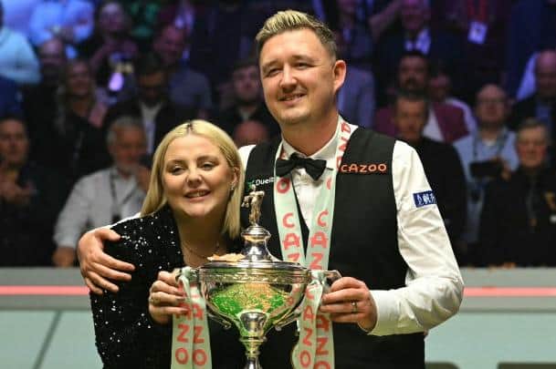 Kyren Wilson poses with the world championship trophy and his wife Sofie